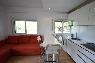 a living room with a red couch and a kitchen at Castelldefels Playa in Castelldefels