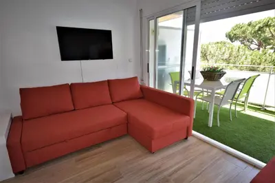 a living room with a red couch and a table at Castelldefels Playa in Castelldefels