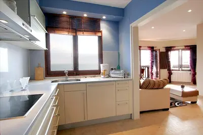a kitchen with a sink and a large window at Sitges Balcony Pool & Seaside Apartment in Sitges