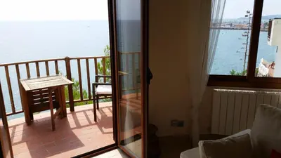 a room with a balcony with a view of the water at Sitges Balcony Pool & Seaside Apartment in Sitges