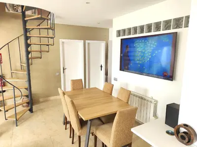a dining room with a wooden table and chairs at Sitges Balcony Pool & Seaside Apartment in Sitges