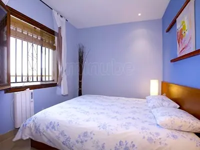 a blue bedroom with a bed and a window at Sitges Balcony Pool & Seaside Apartment in Sitges