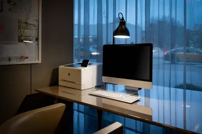 a desk with a computer and a printer and a lamp at AC Hotel Sants by Marriott in Barcelona