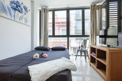 a bedroom with a bed and a tv and a large window at Matarolux 6 in Mataró