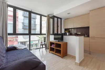 a living room with a couch and a tv and a kitchen at Matarolux 6 in Mataró