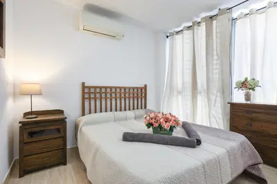 a bedroom with a bed with a bouquet of flowers on it at Matarolux 6 in Mataró
