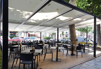 a restaurant with tables and chairs on a deck at Vila Arenys Hotel in Arenys de Mar