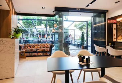 a restaurant with a table and chairs in front of a store at Vila Arenys Hotel in Arenys de Mar