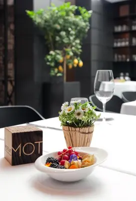 a plate of fruit on a table with a glass of wine at Vila Arenys Hotel in Arenys de Mar