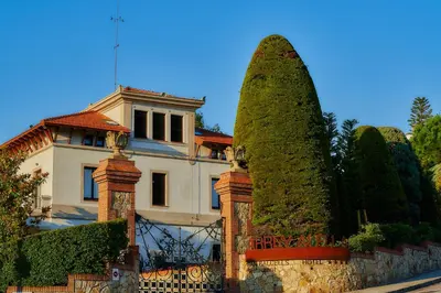 a large white house with a fence and trees at Hotel Arrey Alella in Alella