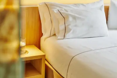 a bed with a white pillow and a side table at Hotel Arrey Alella in Alella