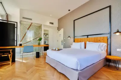 a bedroom with a large white bed and a desk at Hotel Arrey Alella in Alella