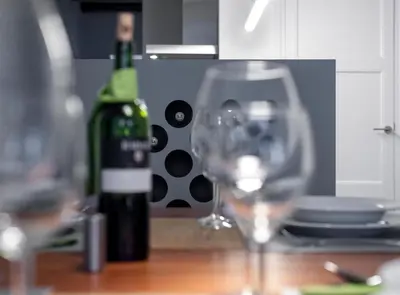 a bottle of wine and two wine glasses on a table at Villaroel · Modern flat in San Antoni in Barcelona