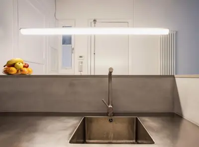 a sink in a kitchen with a light above it at Villaroel · Modern flat in San Antoni in Barcelona