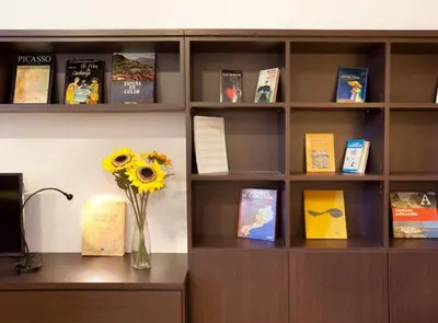 a book shelf with a vase of flowers on a desk at Authentic flat2 in Poble sec - Paralelo in Barcelona