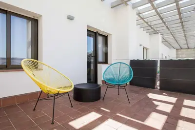 two yellow and blue chairs sitting on a patio at Residencia Universitaria Resa Barcelona Diagonal in Barcelona
