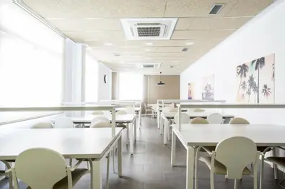 an empty cafeteria with tables and chairs at Residencia Universitaria Resa Barcelona Diagonal in Barcelona