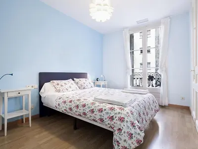 a white bedroom with a bed and a window at Apartment in Barcelona near Passeig de Gràcia in Barcelona