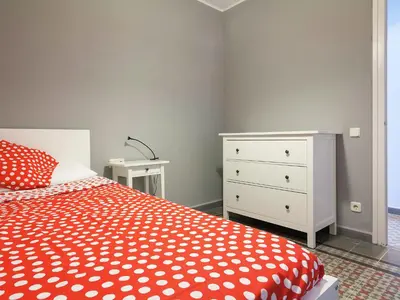 a bedroom with a red and white bed and a dresser at Apartment in Barcelona near Passeig de Gràcia in Barcelona