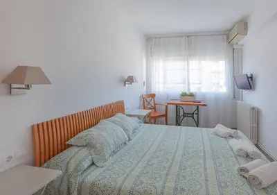 a bedroom with a bed with a blue comforter at Hola! - El Cortijo in Sitges