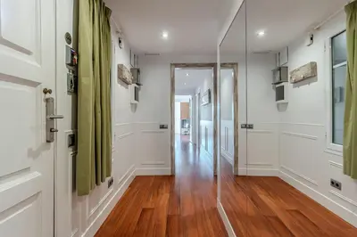a hallway with white walls and a wooden floor at Enjoybcn Fira Apartment in Barcelona