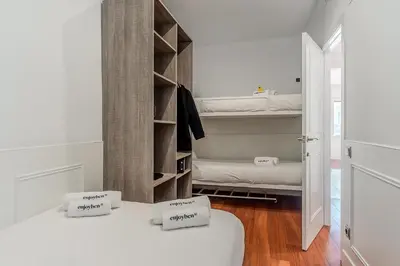 a room with two beds and a closet at Enjoybcn Fira Apartment in Barcelona