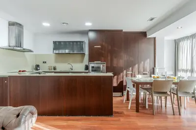 a kitchen and dining room with a table and chairs at Enjoybcn Fira Apartment in Barcelona