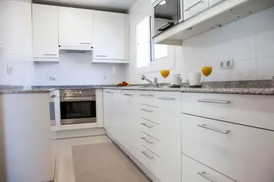 a white kitchen with white cabinets and a sink at New Opening Villa Oasis Terramar in Sitges