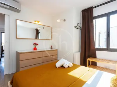 a bedroom with a bed and a mirror at Attic Terrace Montjuïc in Barcelona