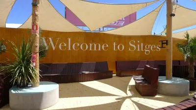 a welcome to stripes sign in front of a building at Mini Apartamento Port Aiguadolç in Sitges