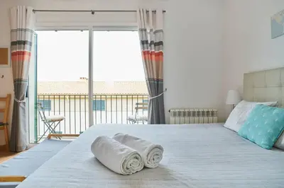 a bedroom with a bed with two rolled towels on it at Casa Garcia in Sitges