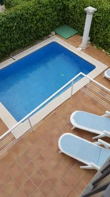 a swimming pool with two lounge chairs and a swimming pool at Casa Garcia in Sitges