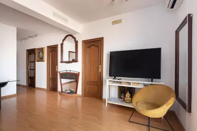 a living room with a television and a chair at Rambla Cat · Penthouse with terrace in Barcelona