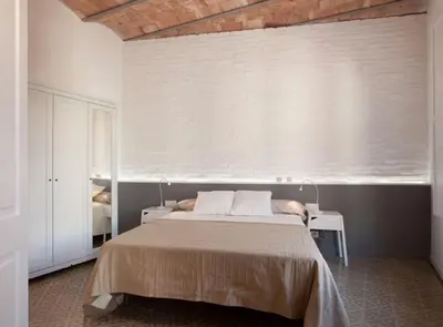 a bedroom with a bed and a white wall at Napoles · Modernist flat close to Sagrada Familia in Barcelona