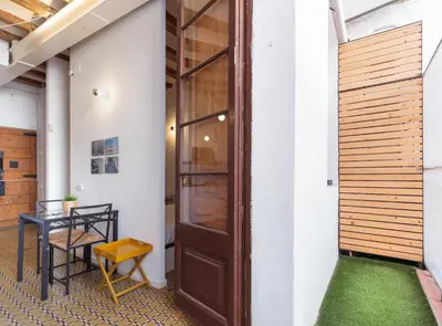 a hallway with a wooden door and a table at Borrell · Near ramblas in Barcelona