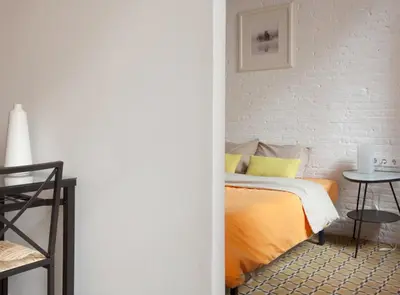 a bedroom with a bed and a white brick wall at Borrell · Near ramblas in Barcelona