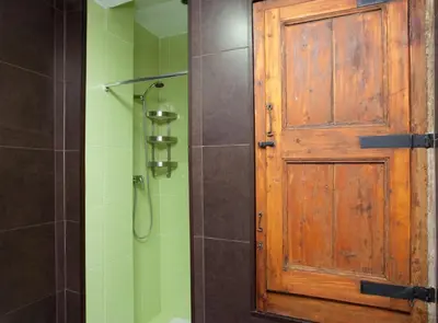 a bathroom with a wooden door and a shower at Borrell · Near ramblas in Barcelona
