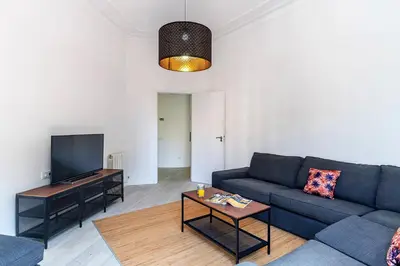 a living room with a blue couch and a flat screen tv at 2215 - AB Calabria Apartment in Barcelona