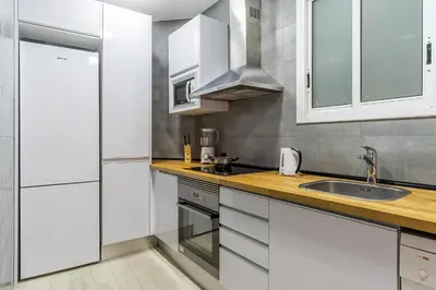 a kitchen with white cabinets and a sink at 2215 - AB Calabria Apartment in Barcelona