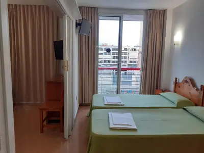 a hotel room with two beds and a window at Apartaments Mar Blau Calella in Calella