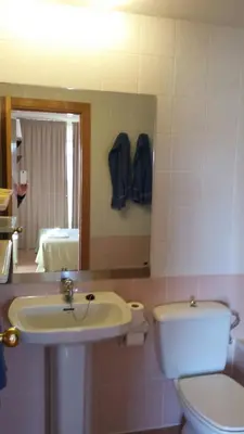 a bathroom with a sink and a toilet and a mirror at Apartaments Mar Blau Calella in Calella