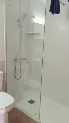 a shower with a glass door in a bathroom at Apartaments Mar Blau Calella in Calella