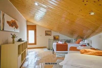 a bedroom with two beds and a wooden ceiling at Alcam Can Macia in Corbera de Llobregat