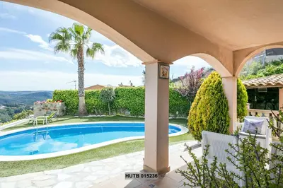 a villa with a swimming pool and a palm tree at Alcam Can Macia in Corbera de Llobregat