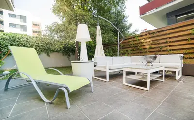 a patio with chairs and a table and an umbrella at Luxury Apartment in Sitges City in Sitges
