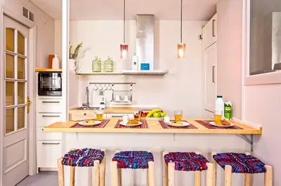 a kitchen with a counter with chairs around it at Sweett - Raco in Barcelona