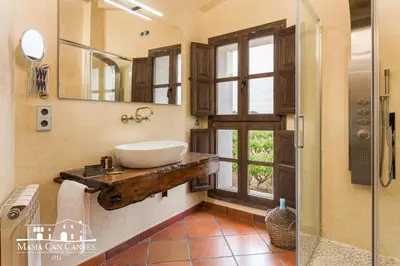 a bathroom with a sink and a mirror at Masia Can Canyes & Spa in San Lorenzo de Hortóns