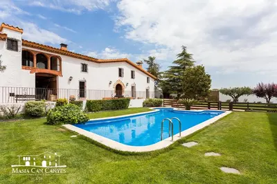 a swimming pool in the yard of a house at Masia Can Canyes & Spa in San Lorenzo de Hortóns