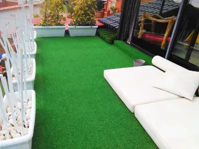 a green carpeted floor on a balcony with white furniture at Casa Miramiranda in Teià