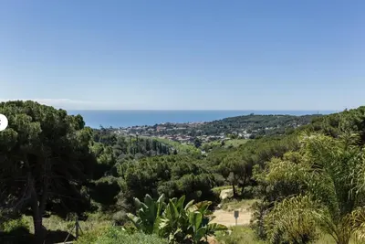 a view of the ocean from a hill with trees at Casa Miramiranda in Teià